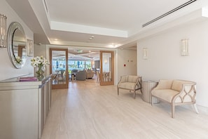 A hotel lobby with a reception desk, seating area, and a view of the outside. - Park Shore-Luxury 3BR/3BA condo on Venetian Bay-boat slip, carport, private Park Shore beach pass (Naples)