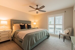 A bedroom with a bed, nightstands, a desk, a chair, a ceiling fan, and a window with blinds. - Park Shore-Luxury 3BR/3BA condo on Venetian Bay-boat slip, carport, private Park Shore beach pass (Naples)