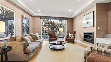 Una sala de estar moderna con un sofá, sillones, una mesa de centro y una chimenea.