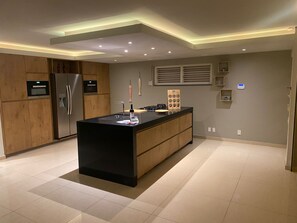 A modern kitchen with a central island, built-in appliances, and a contemporary design. - Villa del Mare - Waterfront Villa by Interhome (Willemstad)
