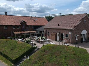 A courtyard with outdoor seating and a brick building with a tiled roof. - Vakantieboerderij Tergracht - t Huuske by Interhome (Epen)