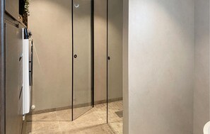 A modern bathroom with a glass shower enclosure, a white sink, and a tiled floor. - Gorgeous home in Fiskåbygd with house a panoramic view (Fiskåbygd)