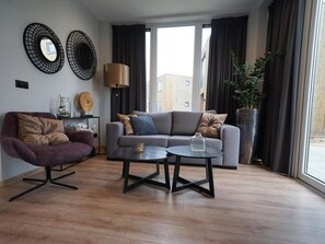 Ein modernes Wohnzimmer mit einer Couch, einem Sessel und einem Couchtisch.