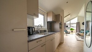 A modern kitchen with a window, a sink, and a coffee maker. - Vakantiepark Aan de Maas - Maas Lande | 4p by Interhome (Kerkdriel)