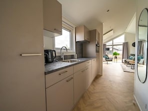 A modern kitchen with a window, a sink, and a coffee maker. - Vakantiepark Aan de Maas - Maas Lande | 4p by Interhome (Kerkdriel)