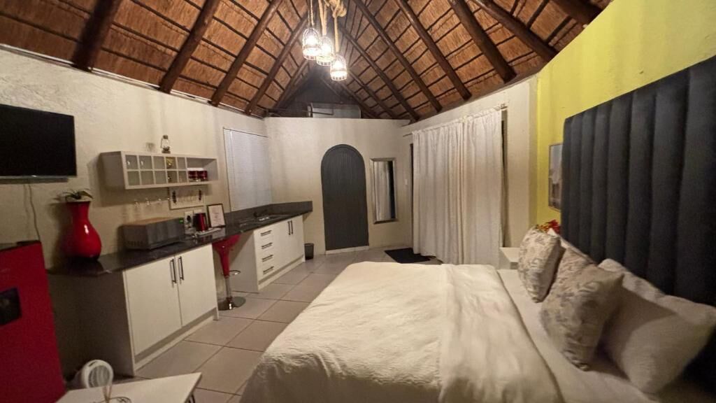 Ein Schlafzimmer mit einem Bett, einem Schreibtisch, einem Stuhl, einem Kleiderschrank und einem Fernseher.