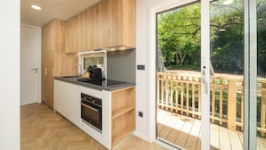A modern kitchen with wooden cabinets, a built-in oven, and a large sliding glass door leading to a deck.