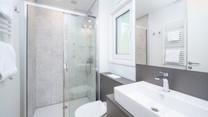 A modern bathroom with a glass-enclosed shower, a white toilet, and a large sink with a mirror above it. - Resort Walsdorf - Moezel Lodge by Interhome (Luxembourg)
