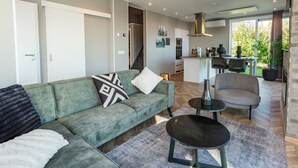 Ein modernes Wohnzimmer mit Sofa, Couchtisch und Kamin.