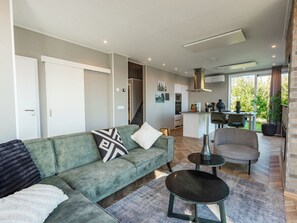 A modern living room with a sofa, a coffee table, and a fireplace. - De Wiedense Meren - Villa Waterrijk | 4p by Interhome (Wanneperveen)