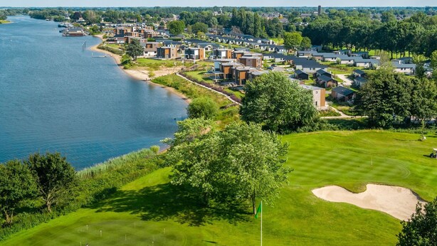 A coastal residential area with modern houses, a golf course, and a river. - Vakantiepark Aan de Maas - Weide Lande | 4p by Interhome (Kerkdriel)