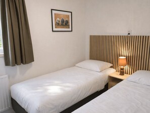 A single-bed room with a headboard, a bedside lamp, and a framed picture on the wall. - De Wiltzangh - Boschborg Lodge | 4p by Interhome (Ruinen)