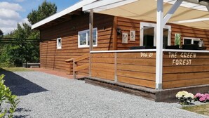 A wooden cabin with a covered porch, labeled 'D06-21' and 'THE GREEN FOREST'. - Wilsumer Berge Resort - Green Forest by Interhome (Wilsum)