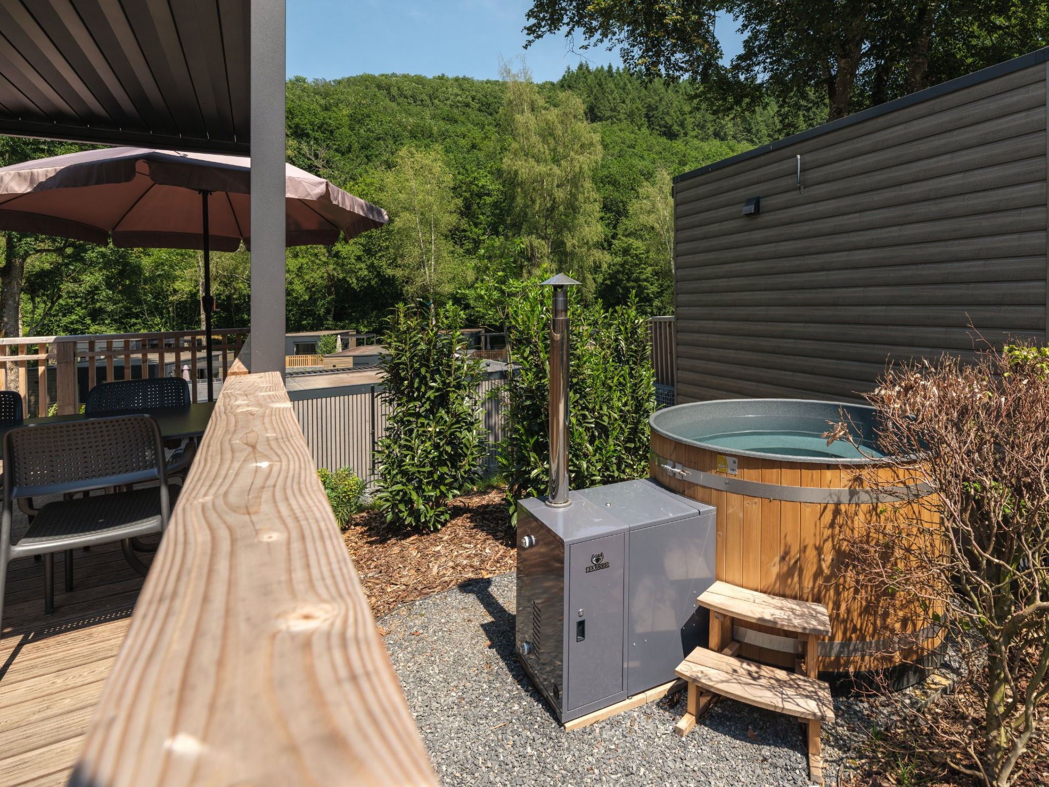 Une terrasse en bois avec mobilier d’extérieur, un jacuzzi et un sauna.