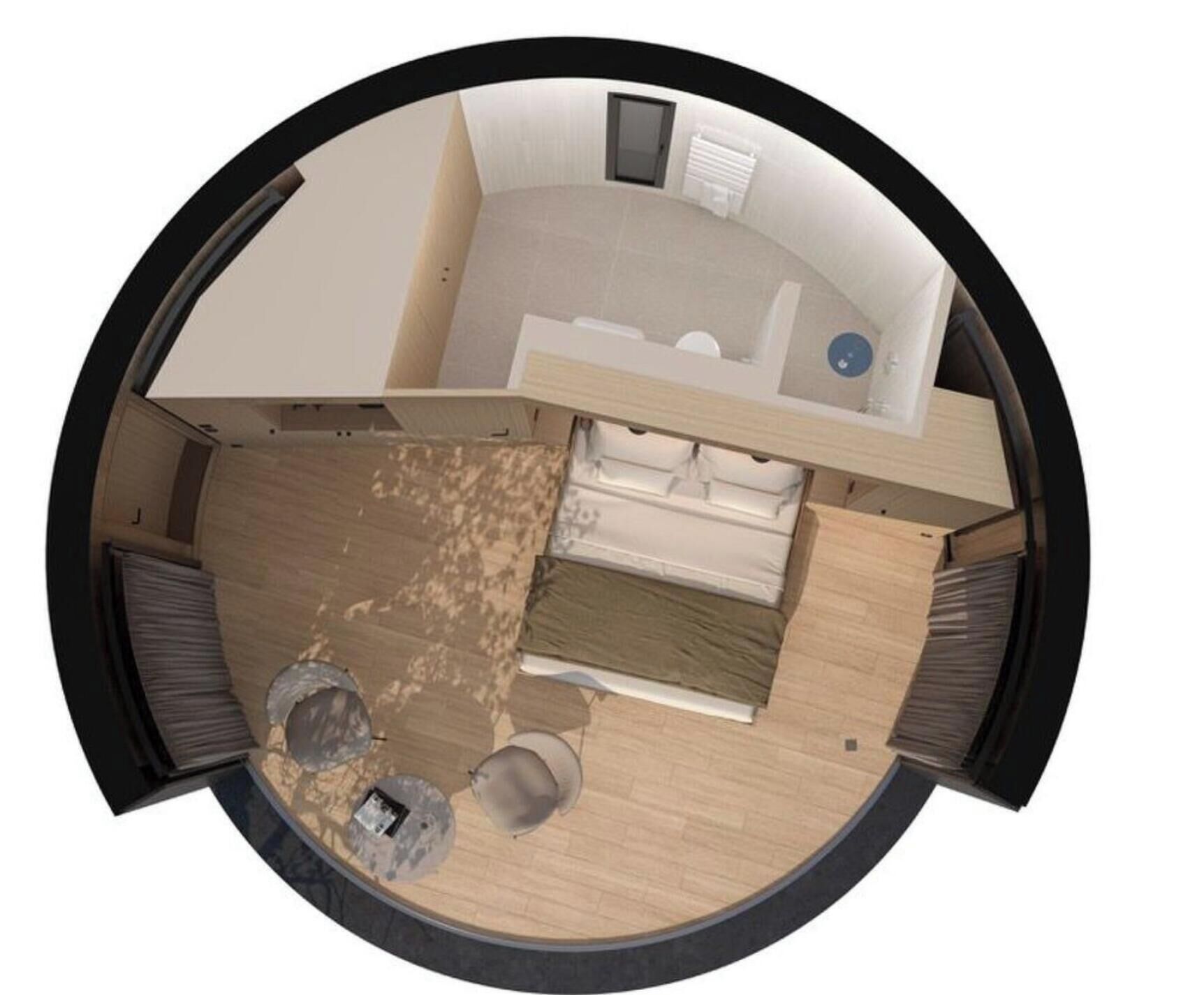 A circular room layout with a bed, a small table, and a chair.
