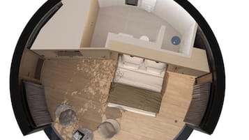 A circular room layout with a bed, a small table, and a chair.