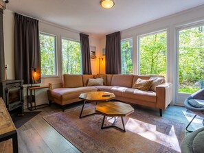 A modern living room with a sectional sofa, a wooden coffee table, and a fireplace. - De Wiltzangh - Vennenborg Lodge | 6p by Interhome (Ruinen)