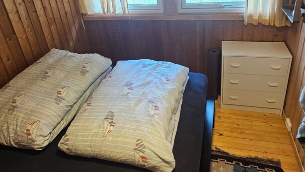 A room with a bed, a dresser, and a window.