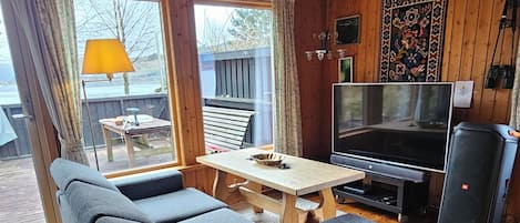 Una sala de estar acogedora con sofá, televisor y piso de madera.