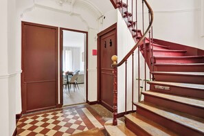 Eine Treppe mit Schachbrettmuster führt zu einem Raum mit Essbereich.