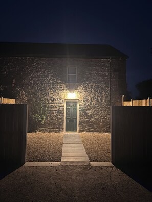 A stone building with a wooden door and a pathway leading to it. - The Lodge at Sandfordscourt House - Luxury Country Stay Near Kilkenny (Sandfordscourt)