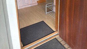 A wooden-framed doorway leading to a kitchen area with a microwave, refrigerator, and a coffee maker. - Lovers Nest (Värmlands län)