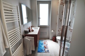 A bathroom with a shower, a toilet, a sink, and a mirror. - Juliet's House (Cagliari)