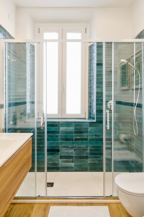 A modern bathroom with a glass-enclosed shower, a white toilet, and a wooden vanity. - Casa e Appartamento Vacanze Gallese 6 (Roma)