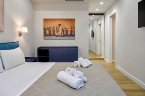 A hotel room with a bed, a painting, a TV, and a hallway. - Casa e Appartamento Vacanze Gallese 6 (Roma)