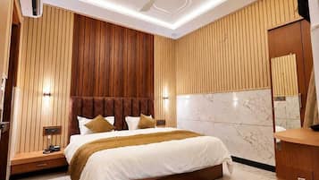 A modern bedroom with a bed, wooden panel walls, a marble floor, and a ceiling fan.