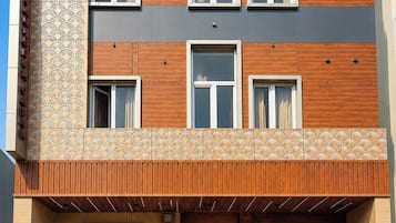 A multi-story building with a wooden facade, multiple windows, and a balcony.