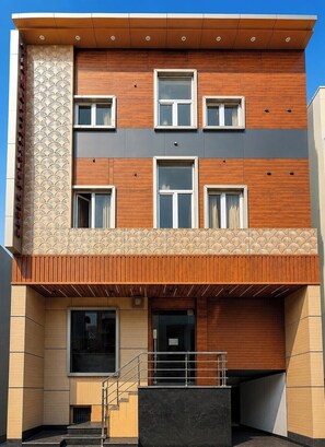 A multi-story building with a wooden facade, multiple windows, and a balcony. - Shri Ram Pujari Seva Sadan (Vrindavan)