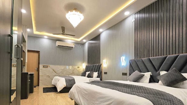 Un dormitorio moderno con una cama grande, un ventilador de techo y una araña.