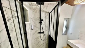 Um banheiro moderno com box, vaso sanitário e pia.