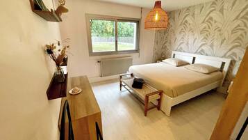 Un dormitorio con cama, escritorio, silla, ventana y radiador.