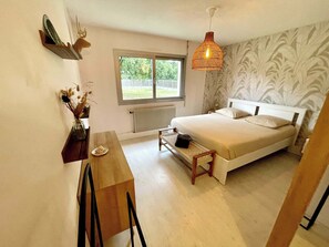 Un dormitorio con cama, escritorio, silla, ventana y radiador.