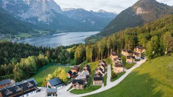 A cluster of wooden houses with a mountain backdrop and a lake.