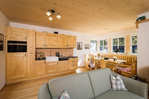 Eine geräumige Küche mit Holzschränken und einem Essbereich mit Tisch und Stühlen.