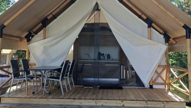 A tented accommodation with a dining area and outdoor seating. - Luxury Glamping Tent 4 (Gulpen)