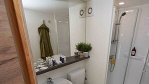 A bathroom with a white sink, toilet, and glass shower enclosure. - Luxury Glamping Tent 4 (Gulpen)