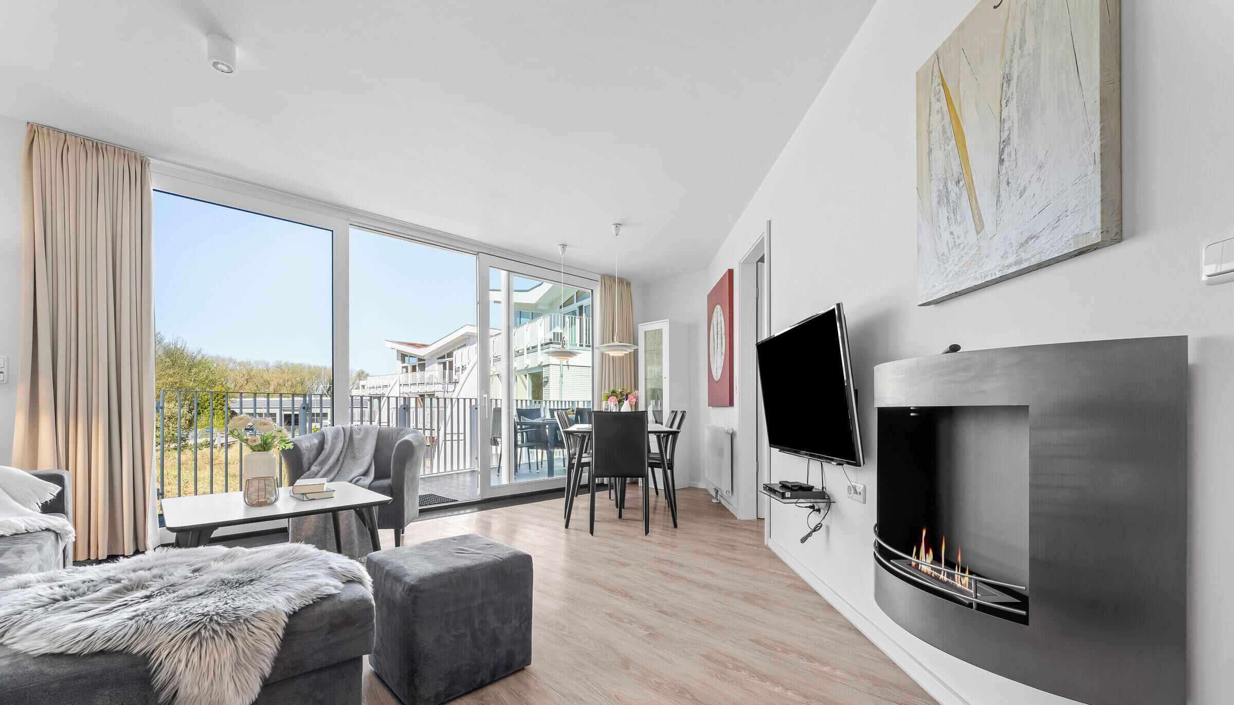 Une chambre d’hôtel moderne dotée d’un balcon, d’une cheminée et d’un coin repas.