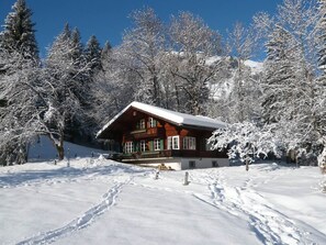 A wooden cabin with a snow-covered roof, surrounded by snow-laden trees and a clear blue sky. - Chalet Maru Appartement/Fewo, Dusche oder Bad, WC, 3 Schlafräume 7-Bett-Wohnung by Interhome (Lenk)