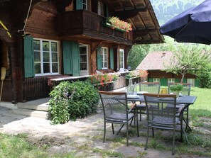 A wooden chalet with a balcony, a table and chairs set outside, and a garden area. - Chalet Maru Appartement/Fewo, Dusche oder Bad, WC, 3 Schlafräume 7-Bett-Wohnung by Interhome (Lenk)