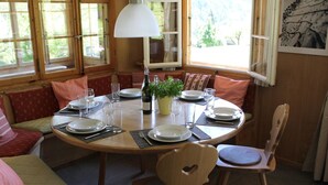 A dining area with a round table set for four, surrounded by wooden chairs and benches. - Chalet Maru Appartement/Fewo, Dusche oder Bad, WC, 3 Schlafräume 7-Bett-Wohnung by Interhome (Lenk)