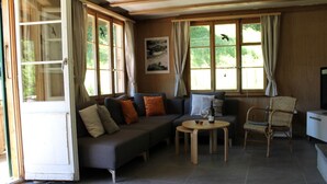 A furnished living area with a sofa, a small round table, and a chair. - Chalet Maru Appartement/Fewo, Dusche oder Bad, WC, 3 Schlafräume 7-Bett-Wohnung by Interhome (Lenk)