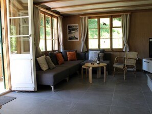 A furnished living area with a sofa, a small round table, and a chair. - Chalet Maru Appartement/Fewo, Dusche oder Bad, WC, 3 Schlafräume 7-Bett-Wohnung by Interhome (Lenk)