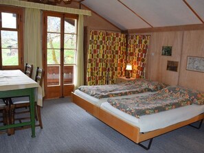 A room with two beds, a table, chairs, a lamp, and curtains. - Chalet Maru Appartement/Fewo, Dusche oder Bad, WC, 3 Schlafräume 7-Bett-Wohnung by Interhome (Lenk)