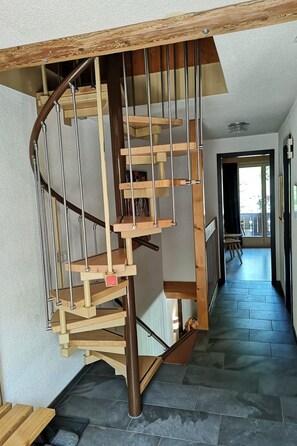 Un escalier en colimaçon avec des marches en bois et des rampes en métal.