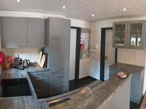 A modern kitchen with grey cabinets, a wooden countertop, and a built-in stove. - Chalet Flöschhorn Appartement/Fewo, Bad, WC, 3 Schlafräume by Interhome (Lenk)