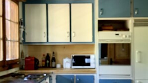 A kitchen with blue cabinets, a microwave, and a refrigerator. - Steirösli 1. & 2. Stock Appartement/Fewo, Dusche und Badewanne, 4 oder mehr Schl by Interhome (Lenk)